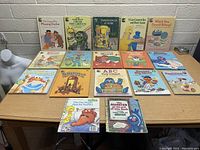 Seventeen vintage Sesame Street kids books laid out on a wooden table showing front cover artwork and titles for identification.