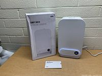 Front view of the Toppin Comfy Air H1 ultrasonic humidifier with digital display and original box alongside manual on table.