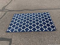 Full view of the Unique Loom Trellis Collection area rug laid flat on pavement, showing the blue and white trellis pattern.
