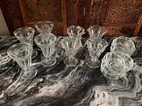 Image showing 6 tall footed glass dessert dishes and 4 small round glass dessert bowls on a marble surface.
