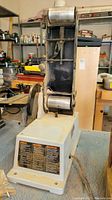 Full view of vertical belt sander including base and belt assembly.