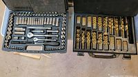 Two black metal cases with Mastercraft branding containing ratchet and drill bit sets.