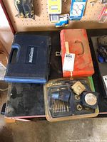 Photo showing Mastercraft blue plastic tool case, red metal toolbox, and Kobalt 13-piece tap and die set packaging on a workbench.