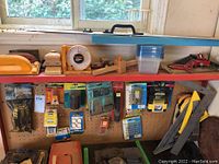 Wide view showing tool shelves with various tools including sanding blocks, rulers, a sorting compartment box, and a handheld sander.