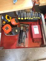 Top view of drawer with T-handle hex keys in stand, tape measures and grease kit in package