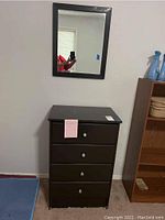 4-drawer chest with dark wood finish, silver knobs, and pink sticky note on top drawer