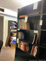 Front view of the black IKEA bookcase filled with various books on shelves to illustrate shelf placement but contents not included in sale.