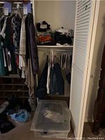Photo of a closet with hanging casual jackets, jeans, and folded shirts on shelf