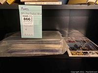 Set of 1980s promotional movie materials and press items in plastic sleeves on a black shelf.