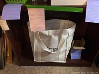 White tote bag labeled 'SICK!' visible under wooden shelf with notes attached to shelf edge