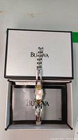 Bulova ladies stainless steel watch inside Bulova box with papers underneath