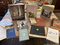 Lot of assorted New England history books, newspaper articles, and memorabilia spread on a table including books titled 'The Hermitage', 'The Royal Island Club', and several others along with newspapers and pamphlets.