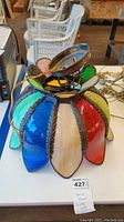 Stained glass swag lamp fixture showing colorful curved glass panels from above and side.