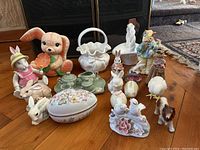 Full view of the assorted ceramic and porcelain figurines, baskets, and mini tea set displayed on wood floor, showing variety including bunnies, animals, and ceramic baskets.