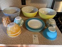 Overview of the entire set showing bowls, plates, and custard cups arranged on countertop.