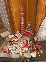 Wide angle showing all items including the animated Santa in car, roll of corrugated paper nearby, ceramic planter shaped like a Christmas tree, various ornaments, and paper holiday items.