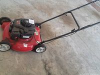 Side view of red Yard Machine push mower showing engine, deck, and wheels.