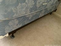 Close-up photo of Serra blue patterned mattress on metal adjustable bed frame.