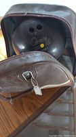 Photo showing Columbia 300 bowling ball partially inside brown Don Carter bag on a wooden surface.