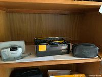 Kodak Advantix preview camera with cloth case and Kodak Cameo 35mm camera with soft black case, shown on shelf