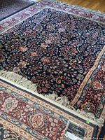 Full flat view of rug showing navy field and floral pattern