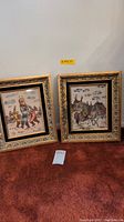Pair of two framed religious themed artwork prints with gold-tone frames shown side-by-side on floor