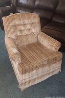 Full view of Broyhill swivel chair showing striped beige and brown fabric upholstery, cushioned armrests, and tufted backrest.