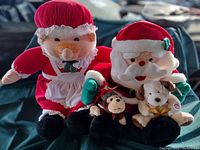 Photo of both plush dolls, Mr. Claus with a plush dog and Mrs. Claus in traditional clothing.