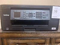 Front view of Brother MFC-J430DW multifunction printer showing LCD screen and control keypad.