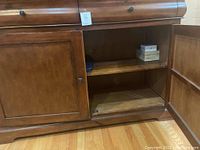 Open door view of the buffet cabinet showing interior shelf space inside one compartment.