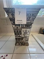 Front view of tall ceramic vase with architectural building design