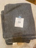Folded gray throw blanket with MaxSold tagging number 39 in the center.