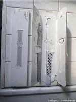 Nike Sport Band in white with black perforated holes on original packaging, laid open showing band inside