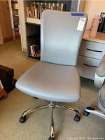 Front view of the gray office chair showing its padded backrest and seat with a chrome base.
