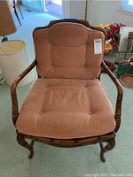 Front and side view of first wooden armchair with cushions showing carved wood frame and tufted dusty pink cushions.