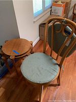 Overall view of three nesting tables and bentwood chair in room.