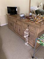 Full side view of the seven drawer wooden dresser, showing construction, drawer handles, and attached mirror.