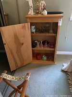Open wooden storage cabinet showing three interior shelves, empty