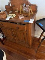 Front and side view of vintage wooden buffet, showing drawer and double cabinet doors with side shelves at top back panel.