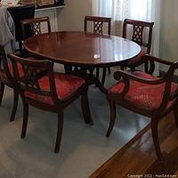 Dining table with six chairs arranged around it showing overall set.