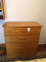 Front view of wooden dresser with four drawers, showing the top surface and drawer handles