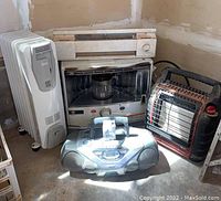 Full lot including DeLonghi heater, Kero-Sun kerosene heater, Big Buddy propane heater, and Phillips radio/CD player on floor.