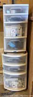 Two stacked plastic storage drawers filled with assorted electrical and plumbing hardware items.