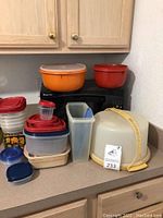 Photo showing full set of plastic containers including cake carrier, bowls, cereal container, and small container without lid.