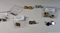 Overview of all cufflinks in the lot showing various pairs including gold, silver, and stone-adorned cufflinks.