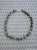 Full view of jade bead necklace laid flat showing graduated bead sizes and gold clasp