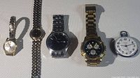 Five watches arranged side by side: four wrist watches and one pocket watch, showing general appearance, condition, and variety.