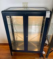 Front view of cabinet showing double glass doors, interior shelves and grow lights illuminated