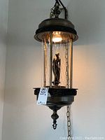 Side view of vintage Mid-Century Modern hanging mineral oil rain lamp with bronze finish and chain suspension.