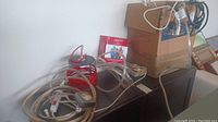 Photo showing coiled clear rope lights, red string lights, and boxes
